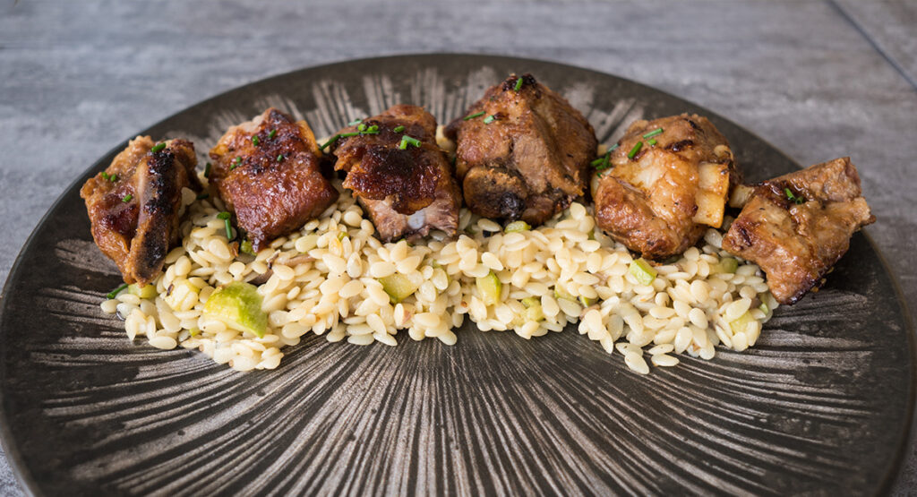 Costilla laqueada sobre cama de falso arroz