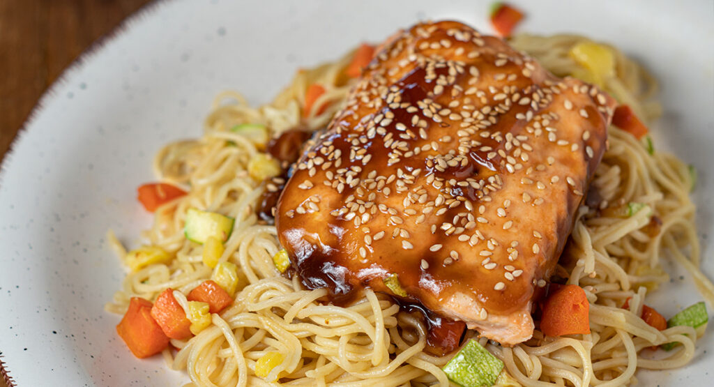 Salmón teriyaki sobre noodles con verduritas