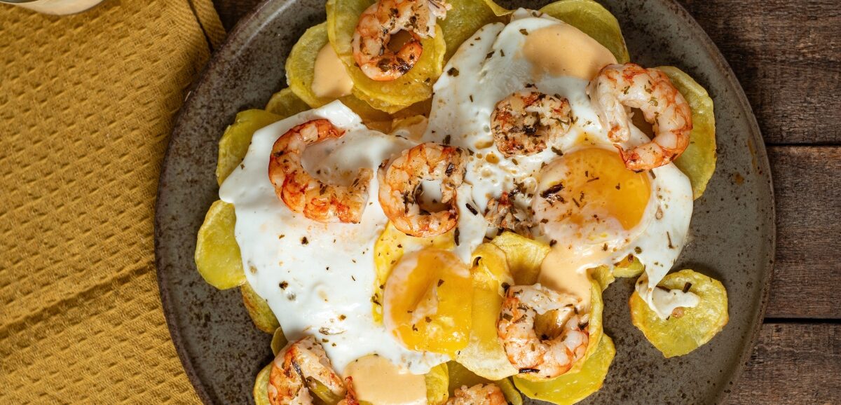 Huevos rotos con gambones al ajillo