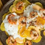 Huevos rotos con gambones al ajillo