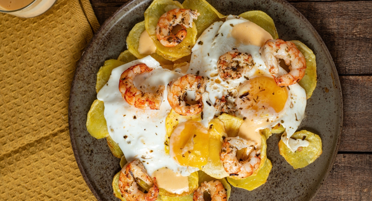 Huevos rotos con gambones al ajillo
